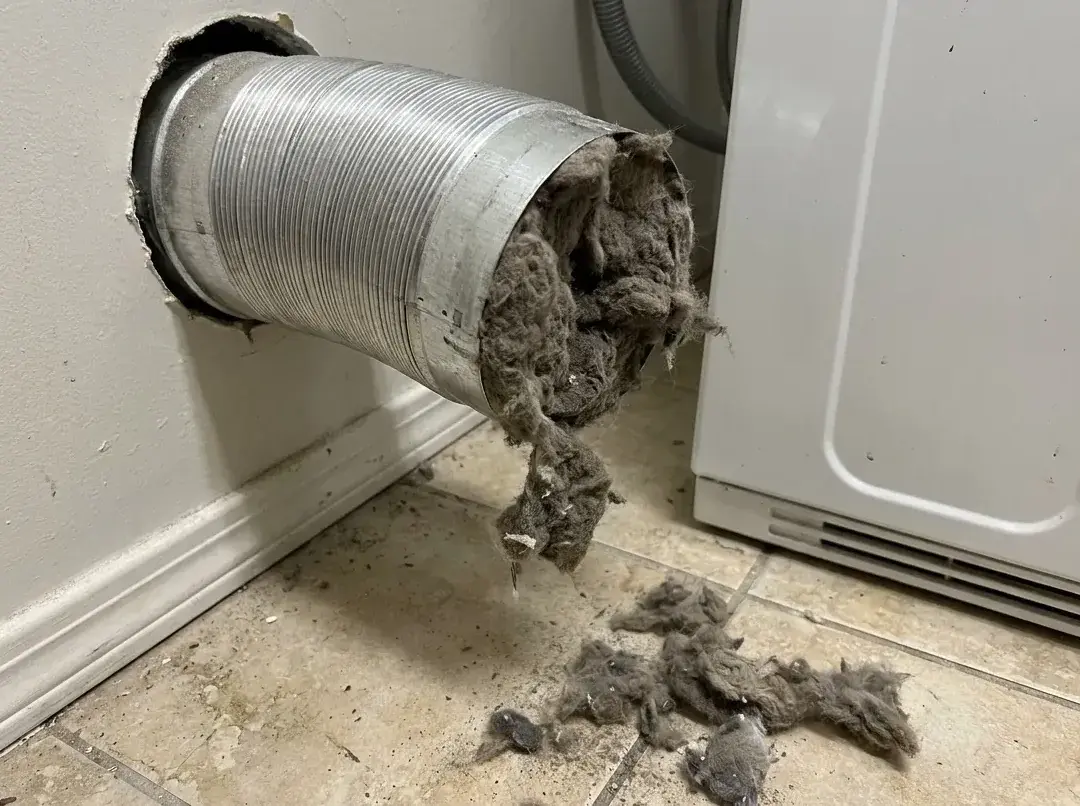 Foil transition hose behind a dryer packed with lint